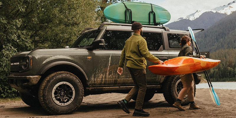 SUV with kayaks parked near a lake