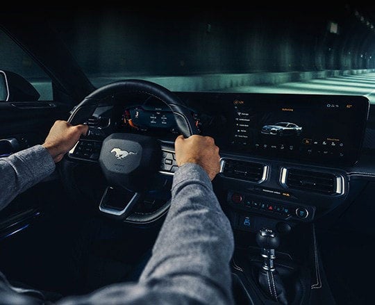 A 2024 Ford Mustang® model interior with a person driving | Joe Hall Ford in Lewiston ID